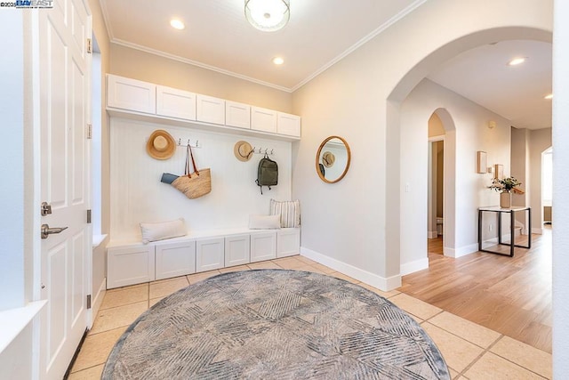 mudroom featuring light tile patterned floors and ornamental molding