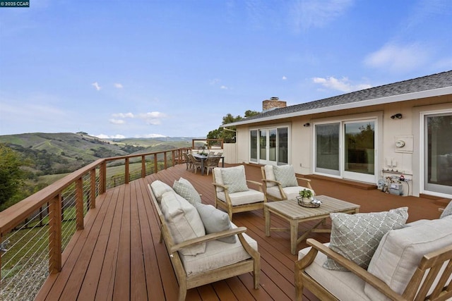 wooden terrace with outdoor lounge area and a mountain view