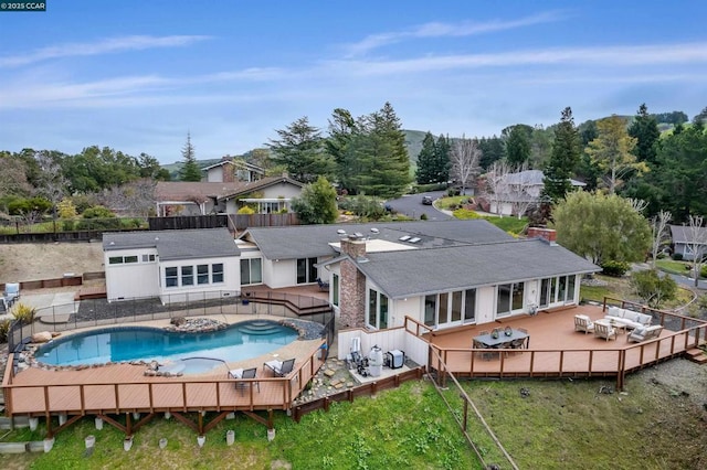 rear view of house with outdoor lounge area and a swimming pool side deck