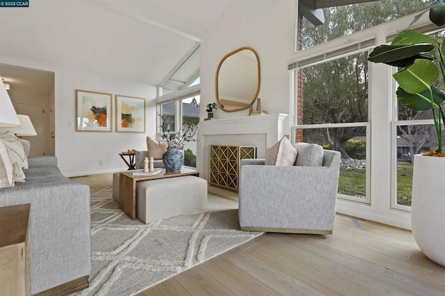 living room featuring beam ceiling, high vaulted ceiling, and light wood-type flooring