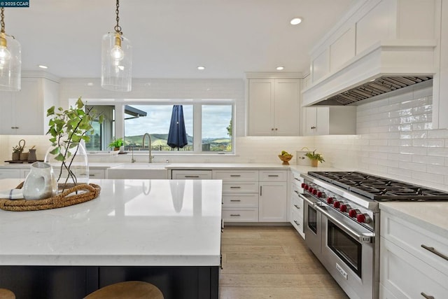 kitchen featuring white cabinetry, double oven range, pendant lighting, and custom exhaust hood