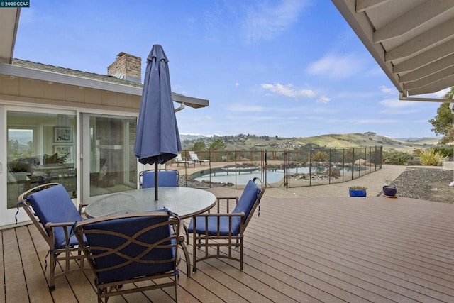 wooden deck with a fenced in pool and a mountain view