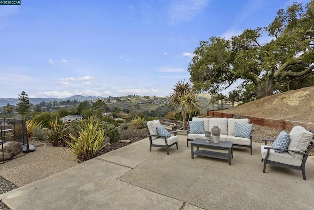 view of patio with an outdoor living space and a mountain view