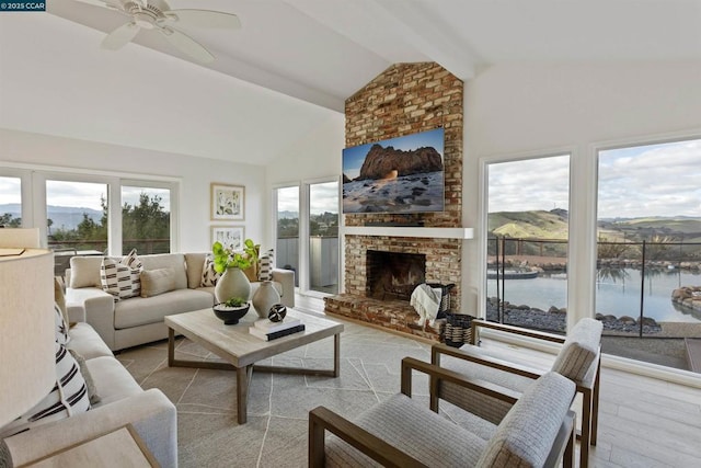 living room featuring lofted ceiling, ceiling fan, a fireplace, a water and mountain view, and light wood-type flooring