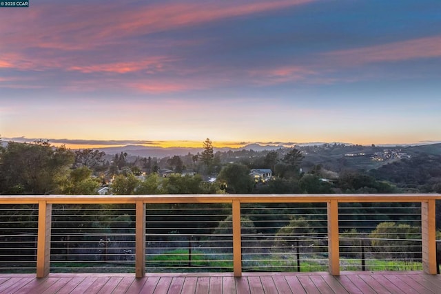 deck at dusk featuring a mountain view