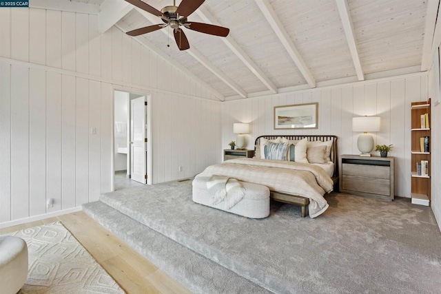 carpeted bedroom featuring ceiling fan and vaulted ceiling with beams