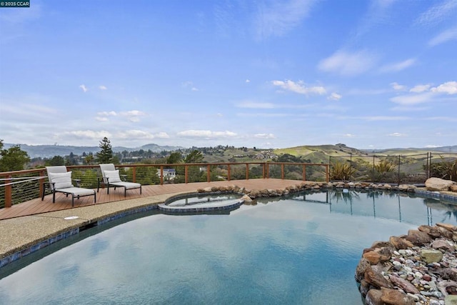 view of swimming pool featuring an in ground hot tub and a mountain view