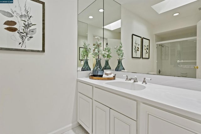 bathroom featuring vanity, an enclosed shower, and a skylight