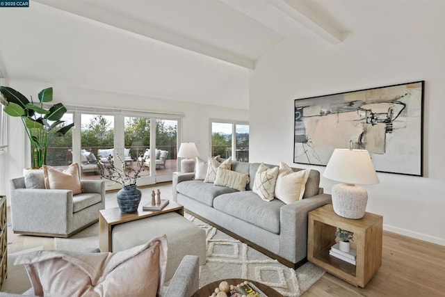 living room featuring lofted ceiling with beams and light hardwood / wood-style floors