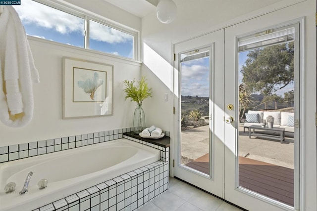 bathroom with tiled tub, tile patterned floors, and french doors