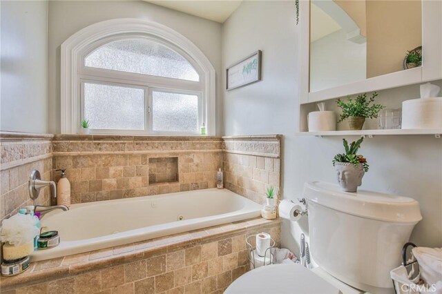 bathroom featuring a relaxing tiled tub and toilet