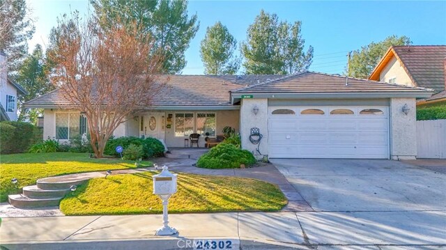 ranch-style home with a garage and a front lawn