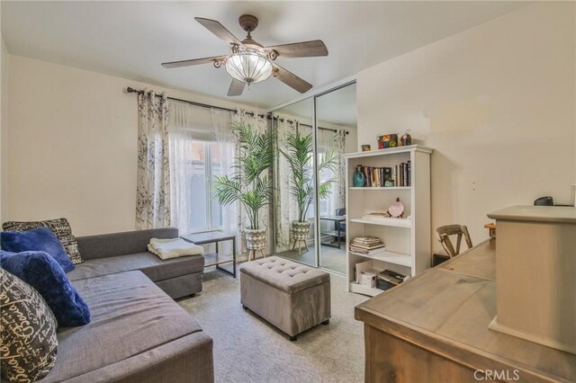 carpeted living room with ceiling fan