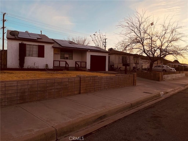 view of front of property featuring a garage and solar panels