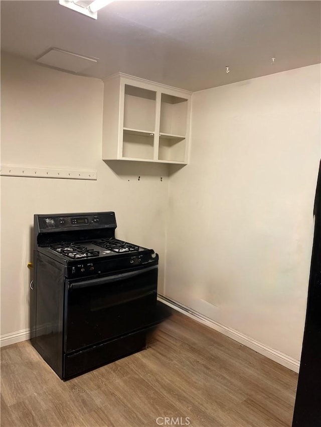 kitchen with black range with gas cooktop and hardwood / wood-style floors