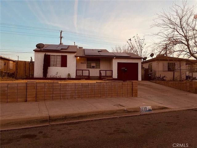 view of front of home featuring a garage and solar panels