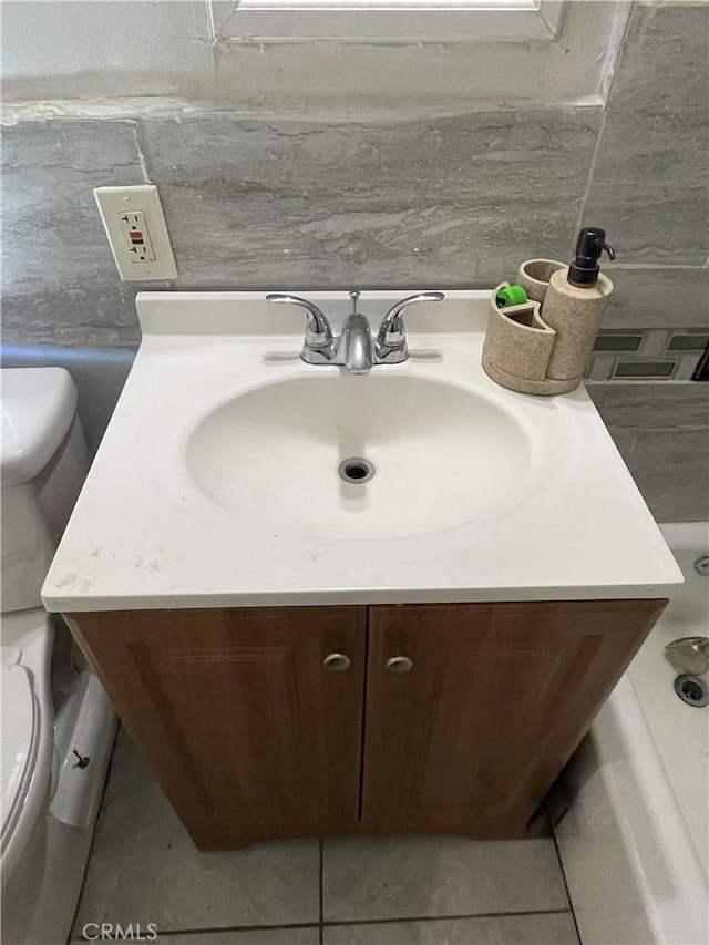 bathroom with tasteful backsplash, tile patterned floors, vanity, and toilet