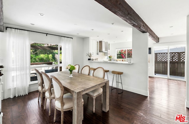 dining area featuring beamed ceiling and dark hardwood / wood-style floors