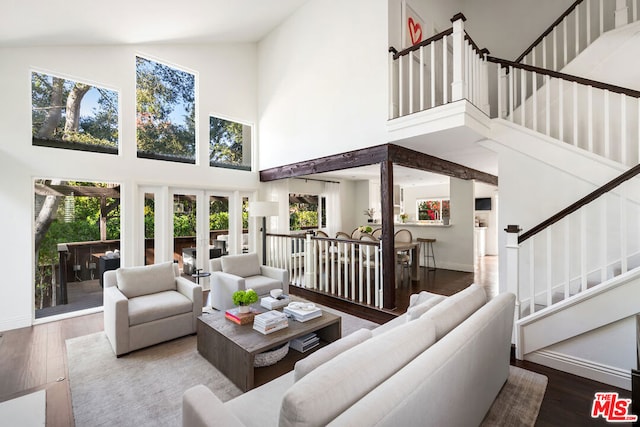 living room featuring french doors, wood-type flooring, and a high ceiling