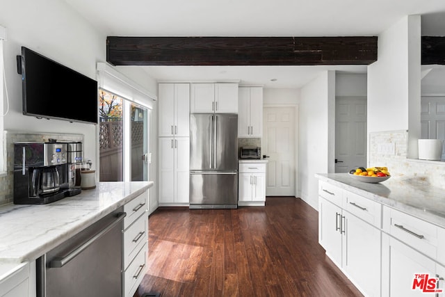 kitchen with appliances with stainless steel finishes, beamed ceiling, white cabinets, dark hardwood / wood-style flooring, and light stone countertops