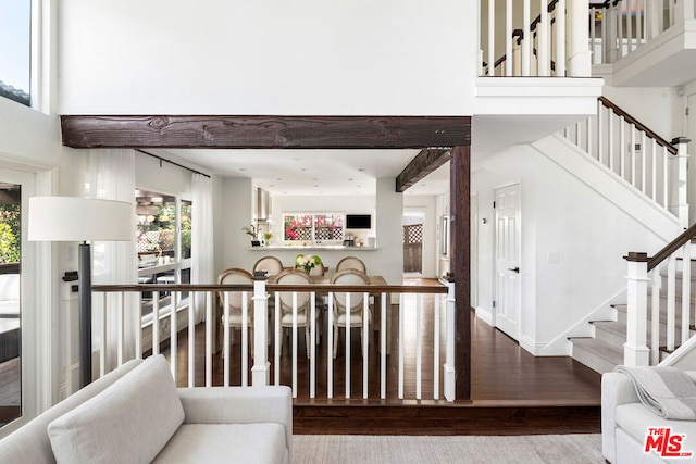 staircase with hardwood / wood-style flooring and a towering ceiling