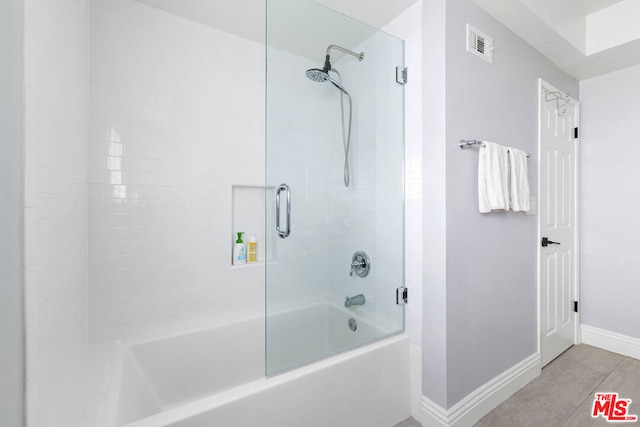 bathroom featuring bath / shower combo with glass door