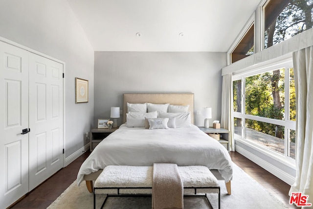 bedroom with vaulted ceiling and dark wood-type flooring