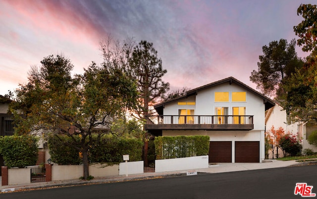 view of front facade featuring a garage and a balcony