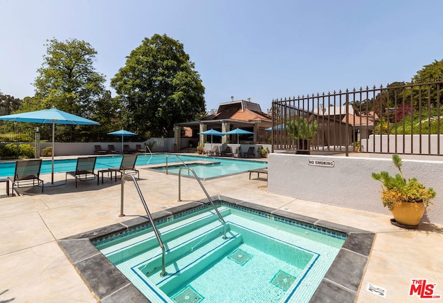 view of swimming pool with a patio area and a hot tub