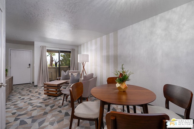 dining space with light colored carpet and a textured ceiling