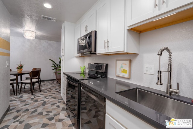 kitchen featuring sink, dishwasher, white cabinetry, range with electric cooktop, and a textured ceiling