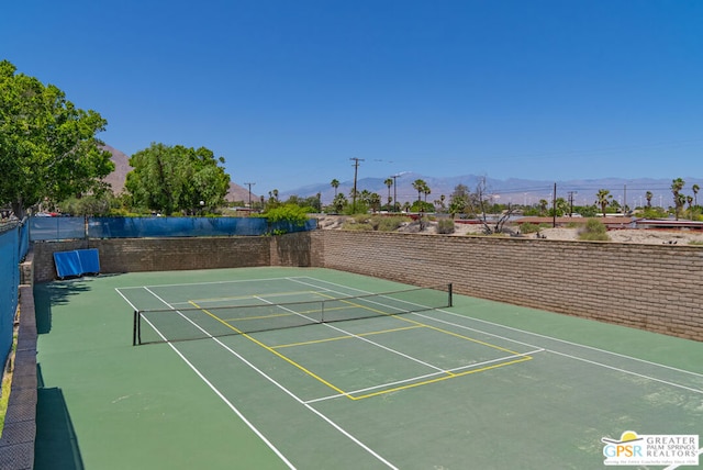 view of sport court with basketball hoop and a mountain view