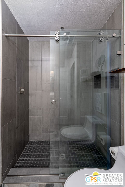 bathroom featuring a shower with door and a textured ceiling