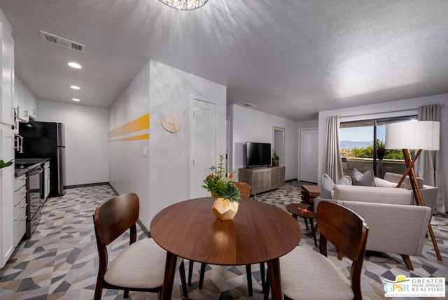 carpeted dining room featuring a textured ceiling