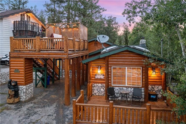 back house at dusk featuring a deck