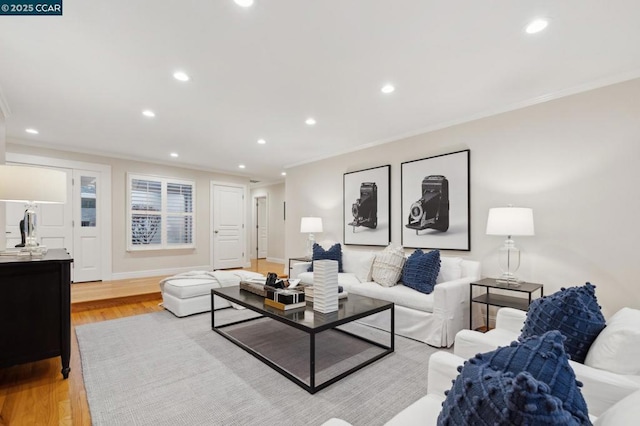 living room with crown molding and light hardwood / wood-style floors