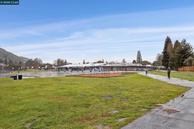 view of property's community with a mountain view and a lawn