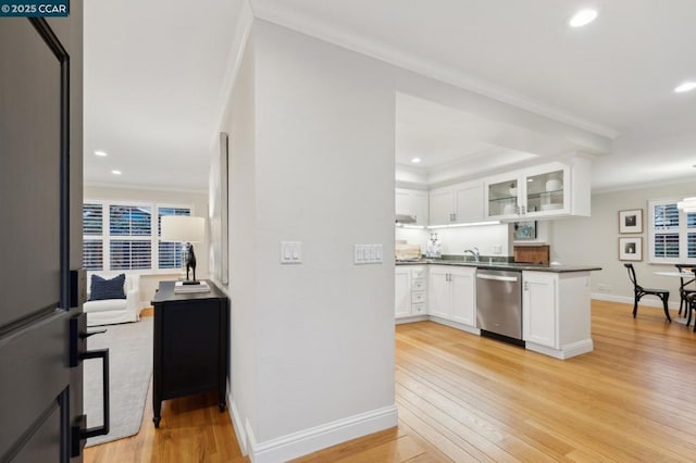 kitchen with white cabinetry, ornamental molding, stainless steel dishwasher, kitchen peninsula, and light wood-type flooring