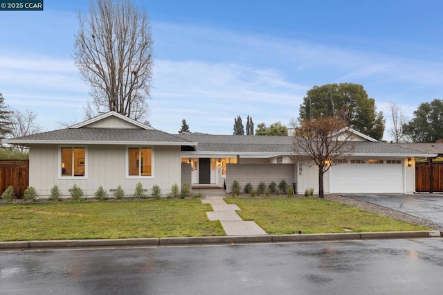 ranch-style house featuring a garage and a front lawn