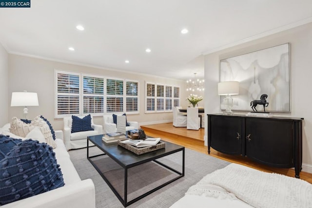 living room featuring crown molding, light hardwood / wood-style flooring, and a chandelier