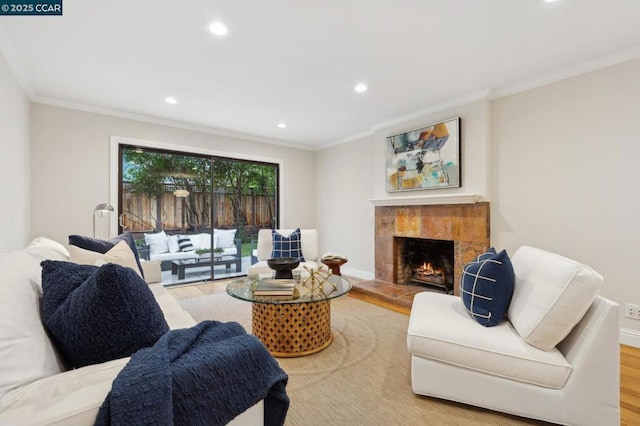 living room featuring a fireplace, ornamental molding, and light wood-type flooring