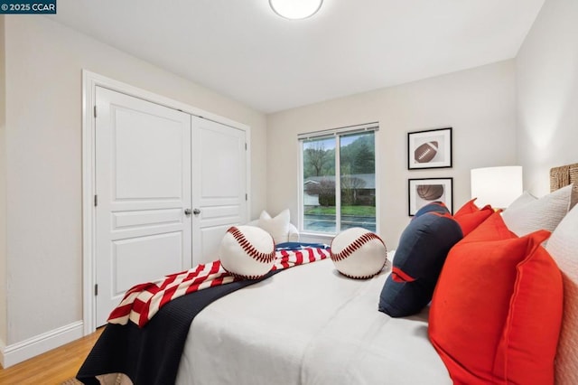 bedroom featuring access to outside, a closet, and light wood-type flooring