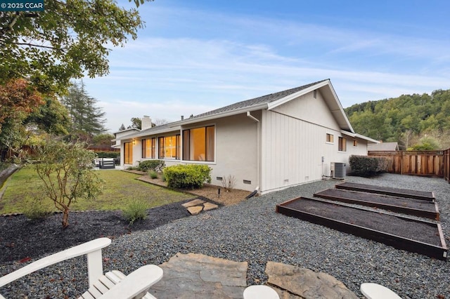 view of side of home featuring cooling unit and a lawn