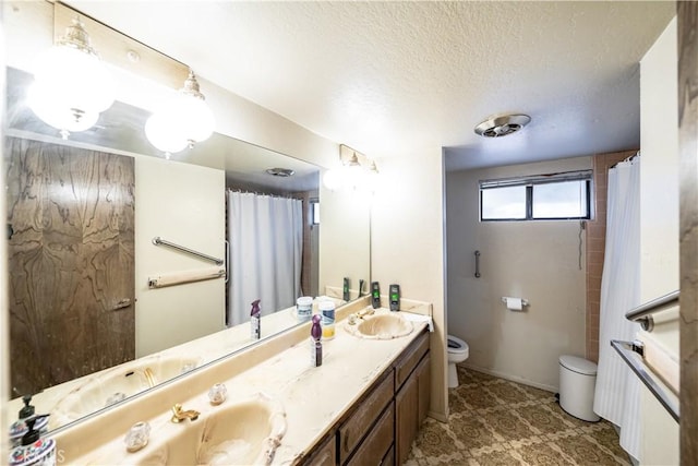 bathroom with vanity, a textured ceiling, and toilet