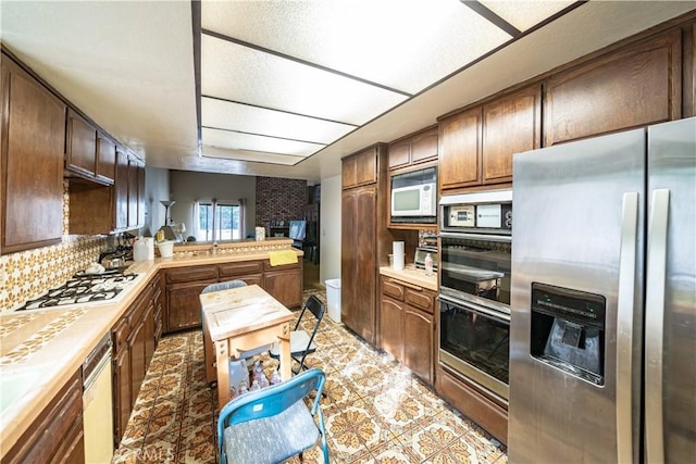 kitchen with tasteful backsplash, stainless steel appliances, and kitchen peninsula