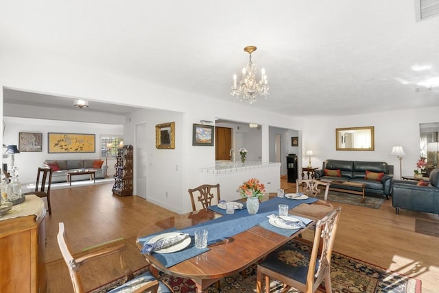 dining space featuring hardwood / wood-style flooring and a chandelier