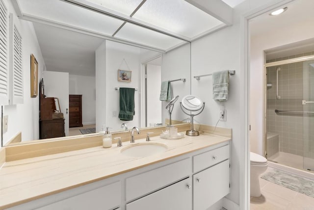 bathroom featuring vanity, toilet, and a shower with shower door