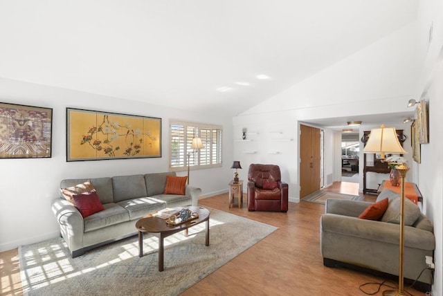 living room featuring lofted ceiling and light hardwood / wood-style floors