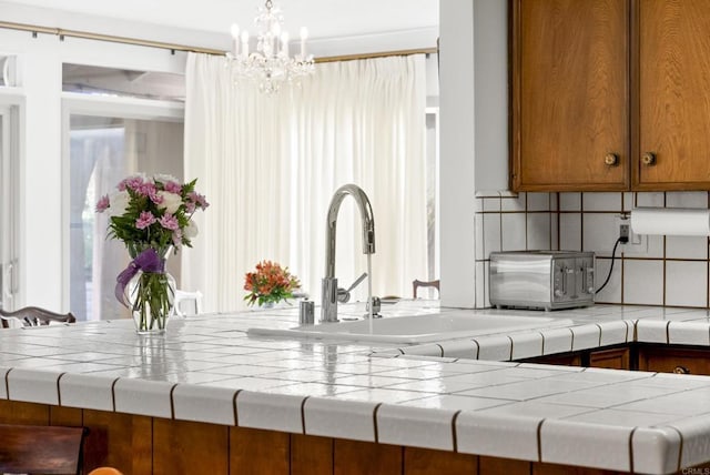 details with sink, backsplash, and a chandelier