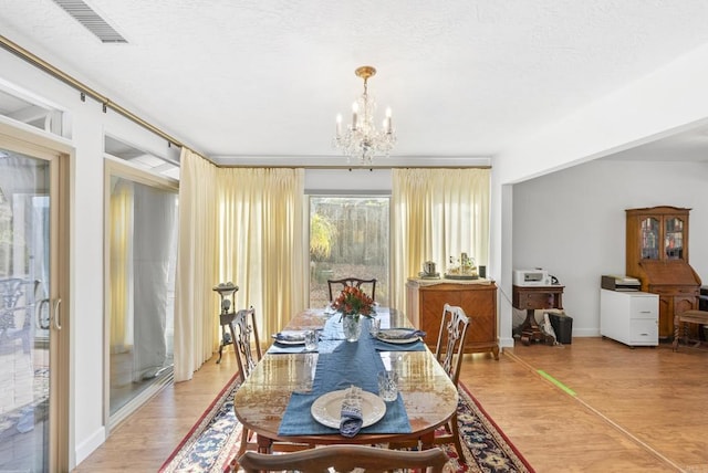 dining room featuring hardwood / wood-style floors and a chandelier